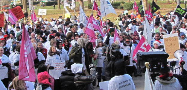 Health care banner Hundreds of CUPE members rallying with flags and signs near Queen's Park