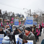 Crowd of a few dozen people with CUPE 3902 signs which say "On Legal Strike"