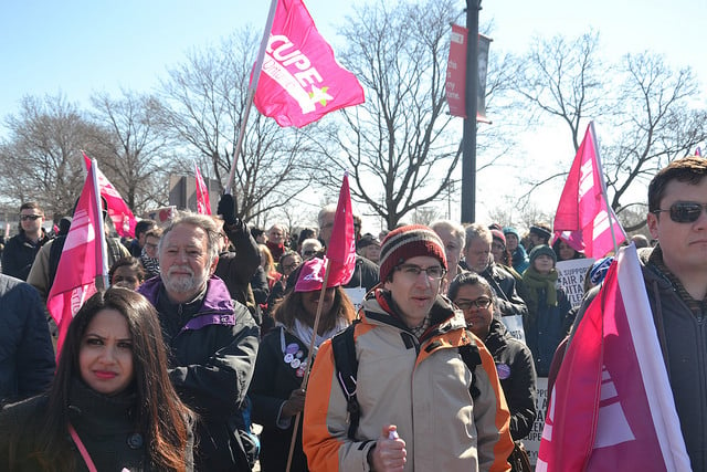 A crowd of people with CUPE Ontario flags