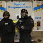 Two paramedics wearing special tactical gear in front of an ambulance with the words "Special Response Unit"