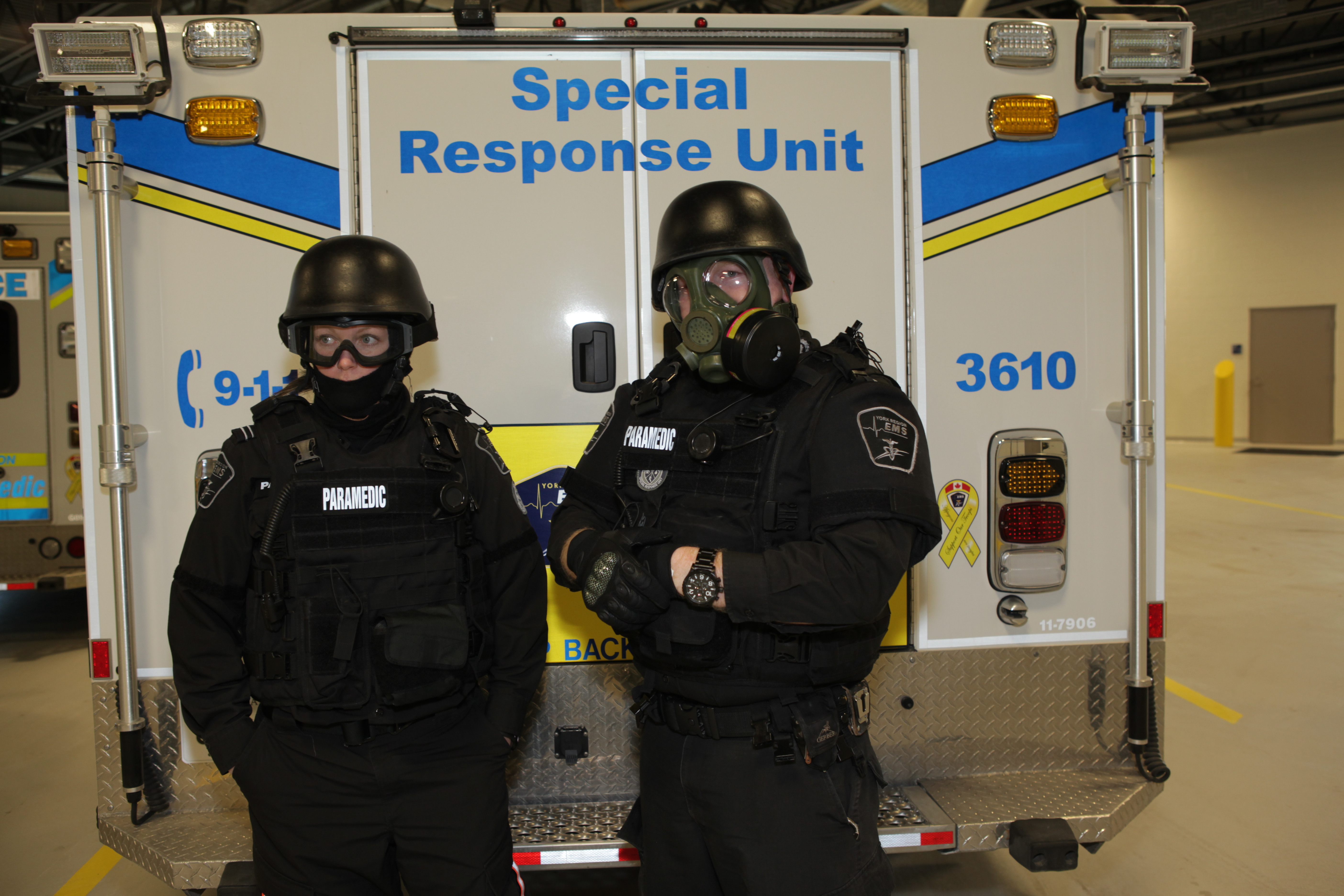 Two paramedics wearing special tactical gear in front of an ambulance with the words "Special Response Unit"