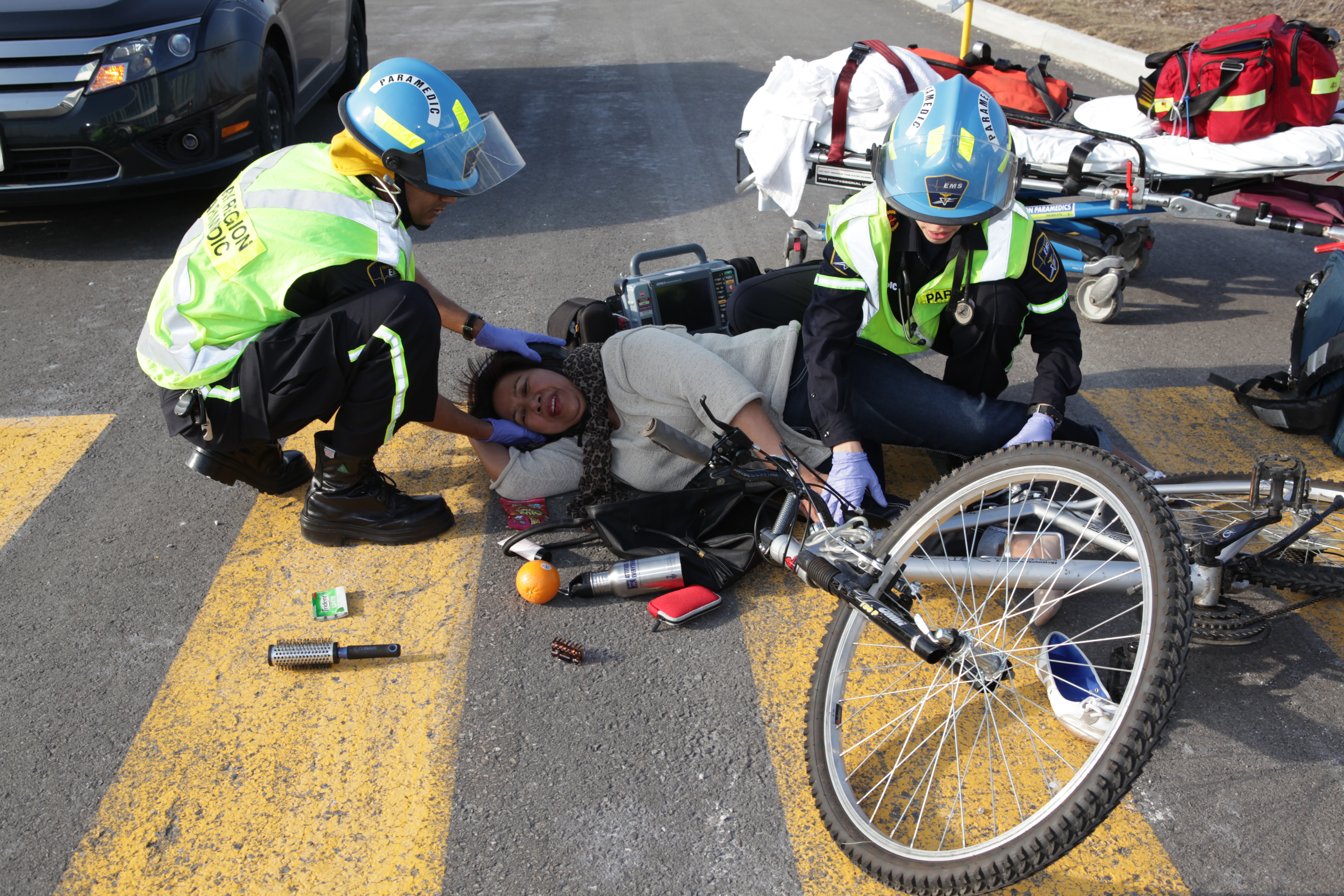 Two paramedics assisting a person with a bicycle who was presumably in a traffic accident