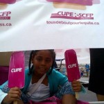 Child holding two CUPE signs