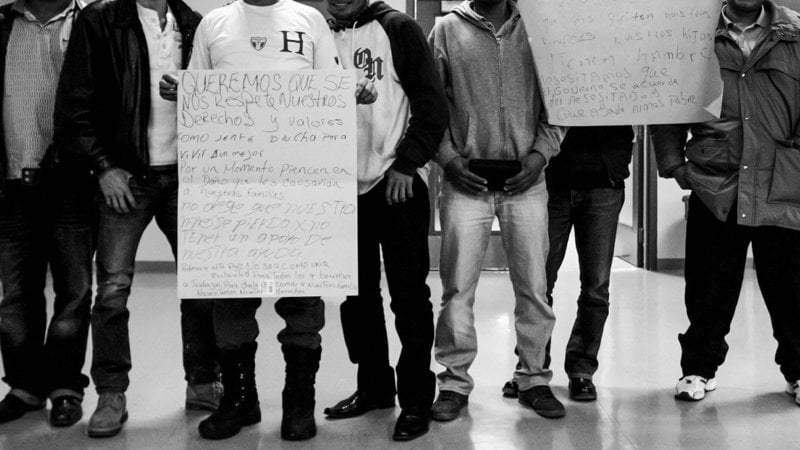 People from the head down holding signs - black and white image