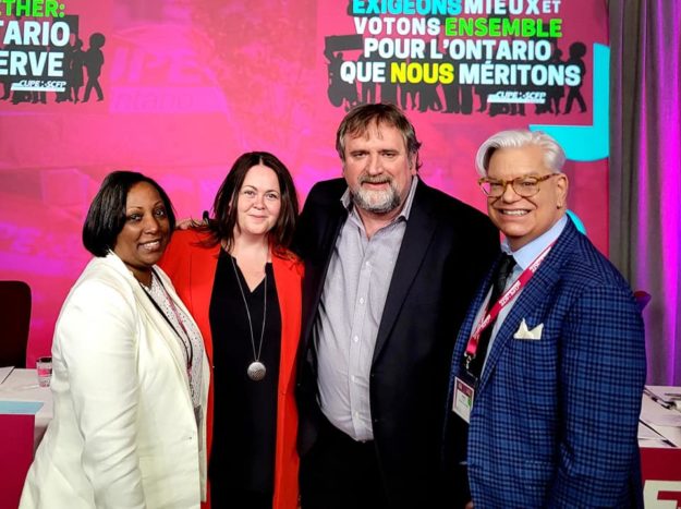 ConventionDay1Newsletter-ExecPhoto Image shows Yolanda McClean, Candace Rennick, Mark Hancock, and Fred Hahn standing together, shoulder to shoulder, against a CUPE Pink background with the Convention 2022 logos in English and French.